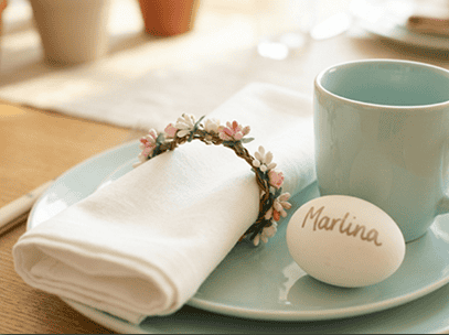 Easter table setting with personalized name tag, napkin, and ceramic cup for festive celebration.