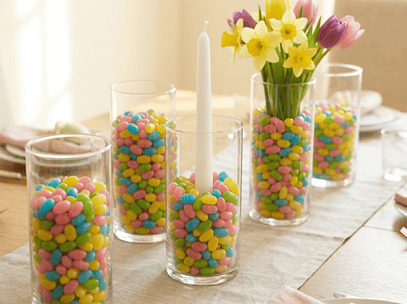 Easter table centerpiece with colorful candies, candles, and fresh flowers for festive celebrations.