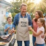 22 Best Father's Day Party Ideas to Celebrate Dad (That He'll Actually Love)2026 Father and kids enjoying grilling at a Father’s Day celebration outdoors.