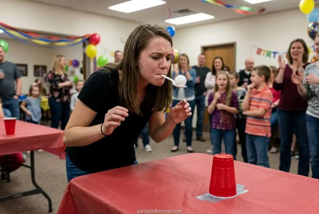 Woman participating in a spoon race at a birthday party. Minute to Win It Games for Parties
