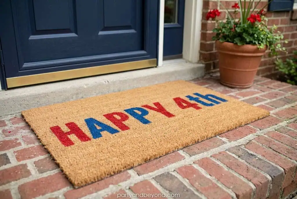 DIY patriotic coir doormat painted with stars and Happy 4th lettering 4th of July Decorations on a Tight Budget