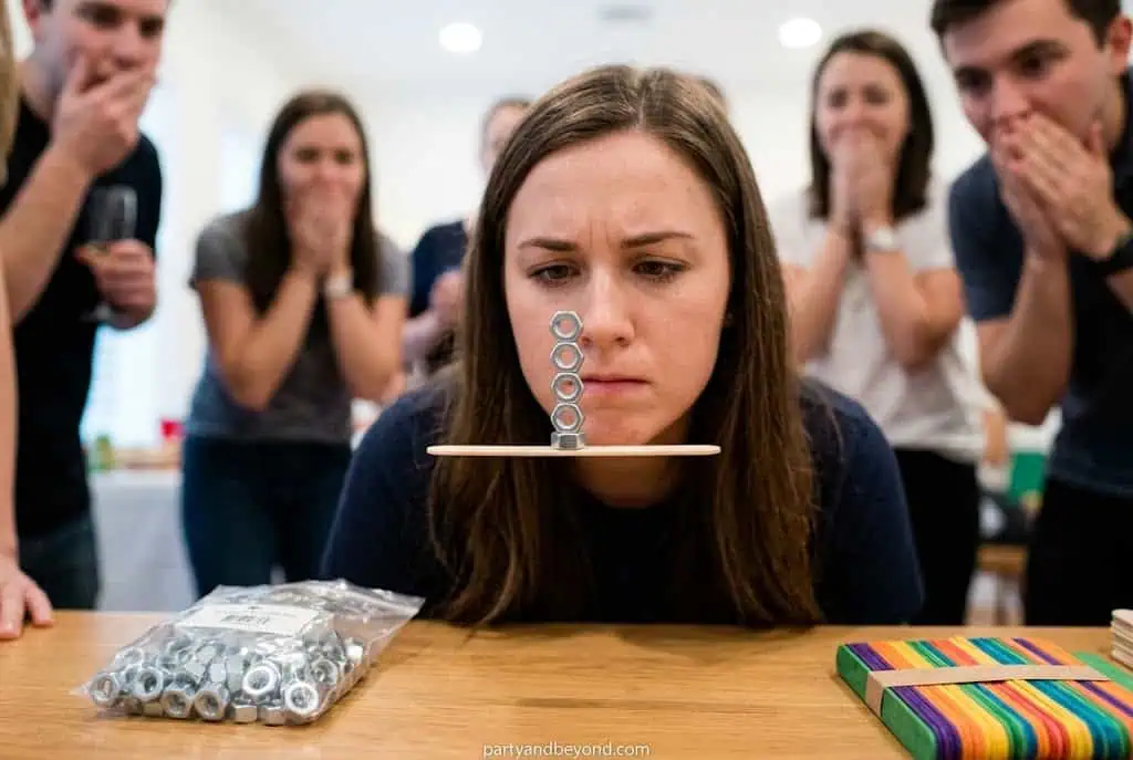 Woman playing ring toss game at party with friends, fun outdoor activity. Minute to Win It Games for Parties
