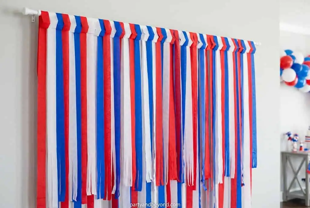 Red white and blue streamer backdrop for 4th of July party photo booth
