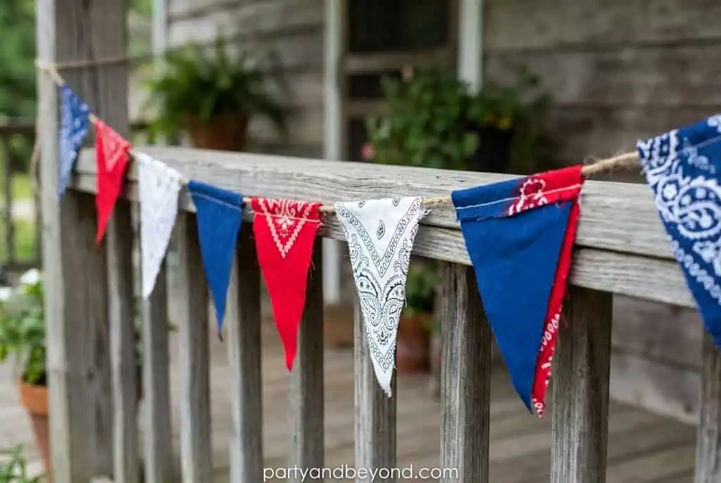 Handmade red white and blue fabric bunting hanging on a porch for 4th of July