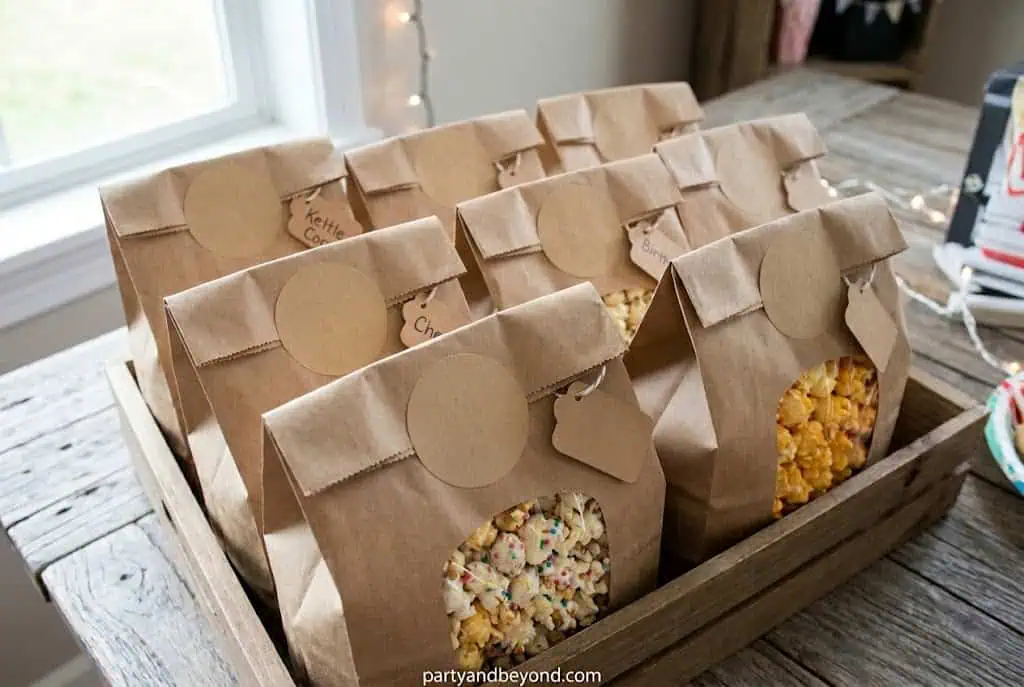 Assorted popcorn bags in a wooden tray for party favors and celebrations.