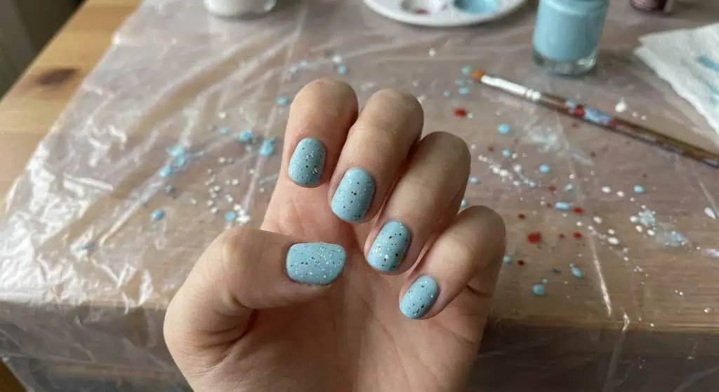 Light blue nails with red and white speckles for a textured summer patriotic manicure.