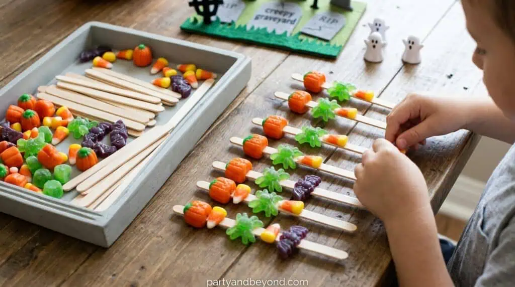Participants balancing small candies on a craft stick held in their mouth during a Halloween party game.
