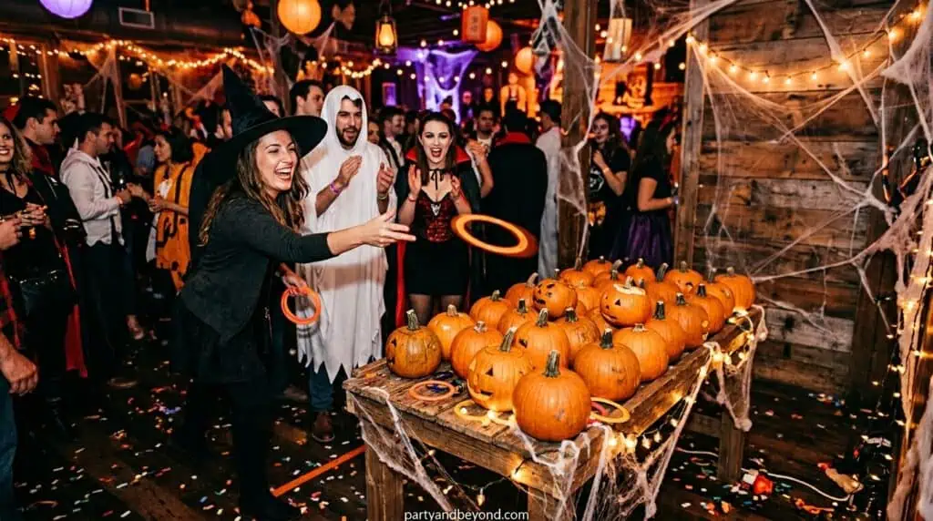 Guests throwing rings toward mini pumpkins in an outdoor Halloween party game setup.