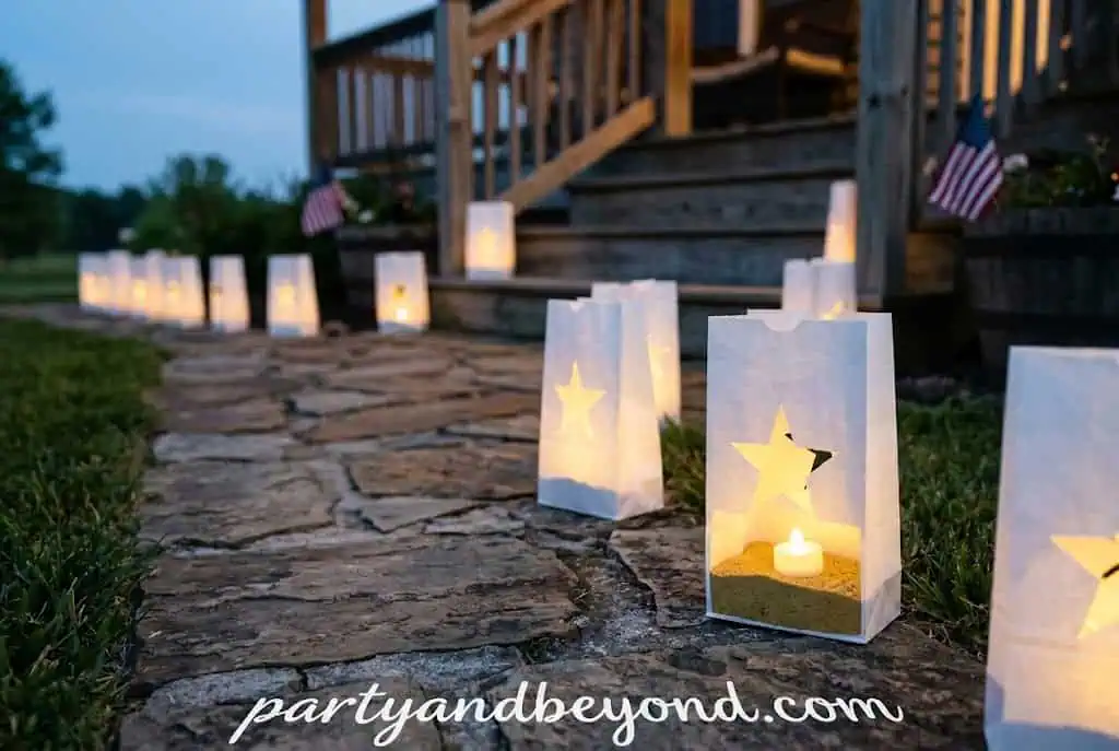 Glowing patriotic luminary bags lining a walkway at a 4th of July party