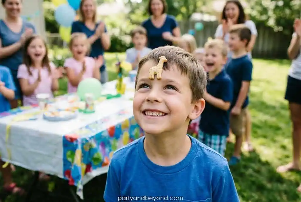 Child balancing a vanilla wafer cookie on their forehead during a fun birthday party game