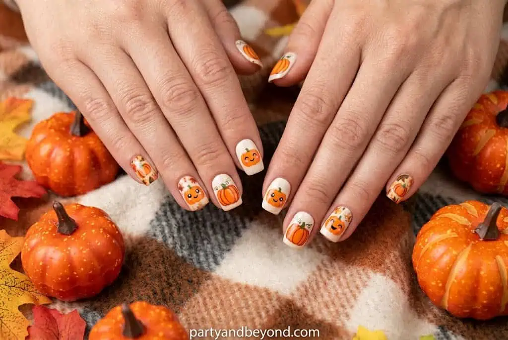 Cute kawaii pumpkin nail art with smiling pumpkin face on pastel orange nails.