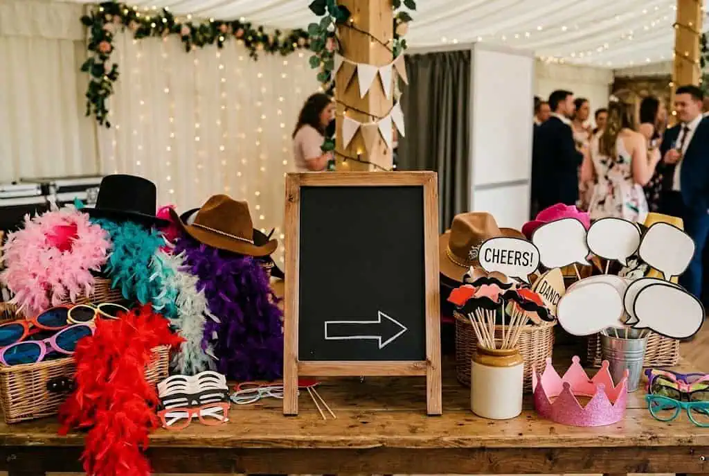 Graduation photo booth props including caps, glasses, and signs arranged for guests