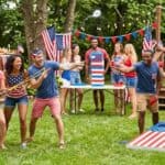 Best 4th of July Party Games for Adults That Get Everyone Involved Adults playing fun outdoor lawn games at a colorful backyard Independence Day celebration β Best 4th of July Party Games for Adults That Get Everyone Involved