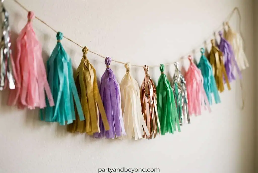 Handmade tassel garland in school colors hanging across graduation party backdrop