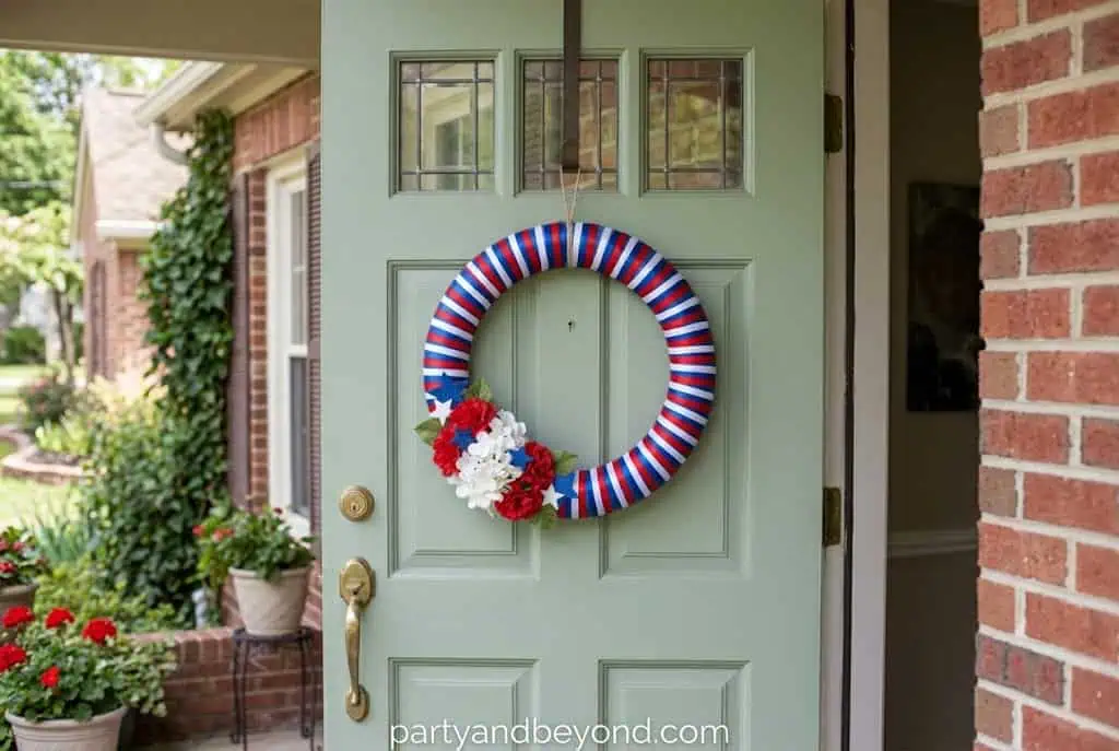 DIY red white and blue wreath hanging on a front door for Independence Day