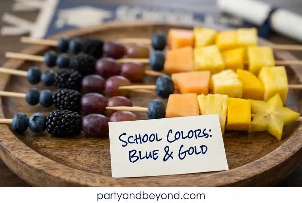 Fresh fruit skewers arranged in school colors for a graduation party food table