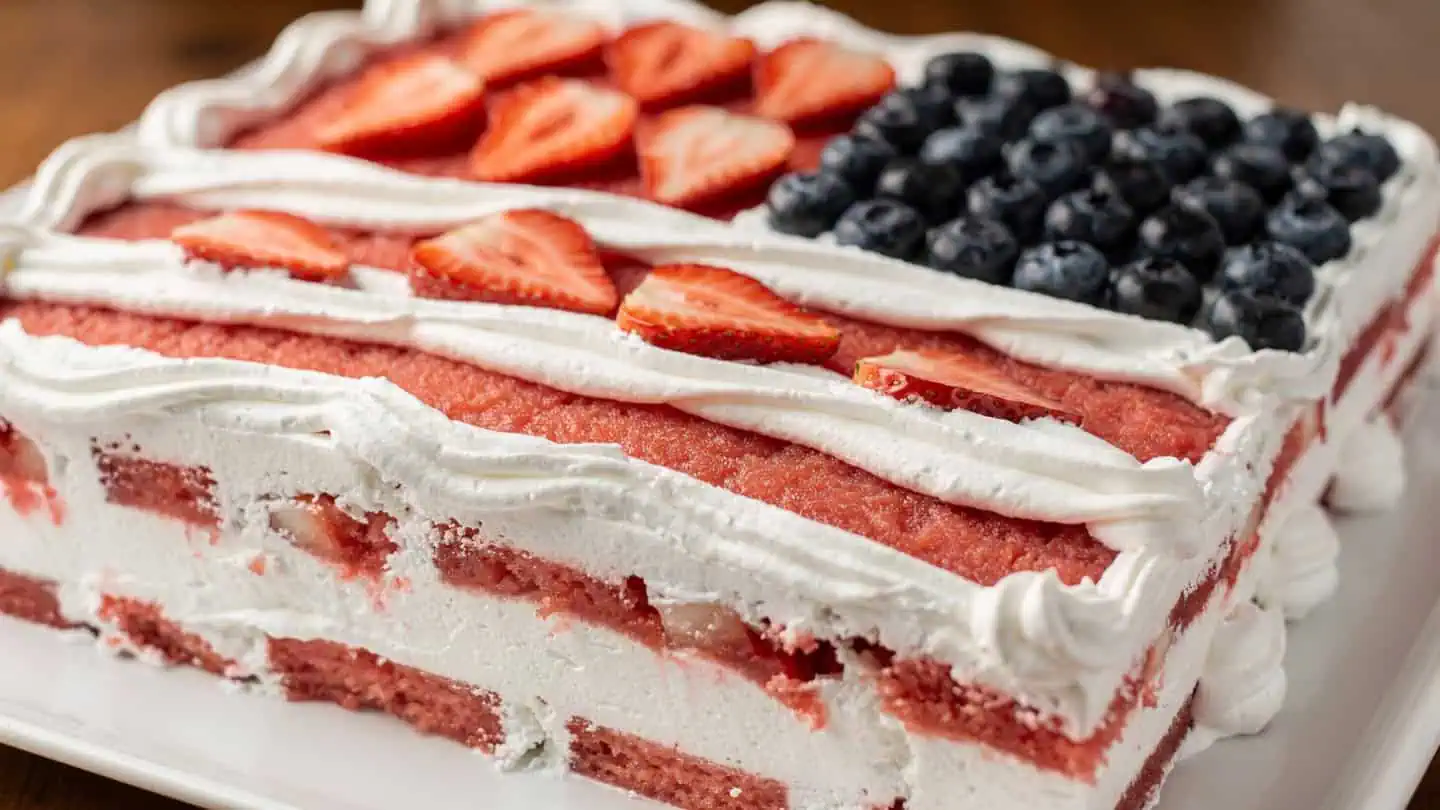Watermelon flag cake no-bake 4th of July dessert with Cool Whip frosting, strawberry stripes, and blueberry corner on a white serving platter