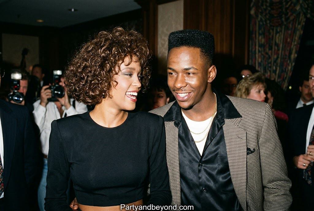 80s-inspired Black celebrity couple costume with sequin dress and retro leather jacket.