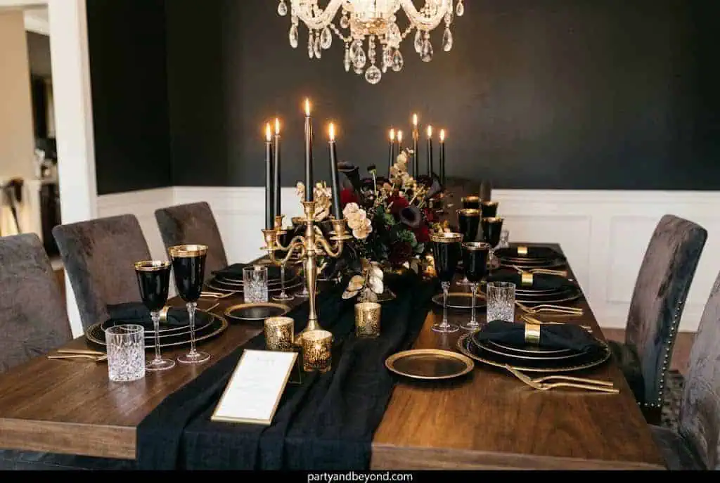 Spooky Halloween graveyard themed dessert table with tombstones and pumpkins.