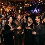 21 Halloween Party Themes for Adults (2026: Decor, Food & Budget Per Theme) Halloween costume party with guests in spooky and creative outfits, enjoying drinks and dancing in a.