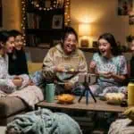 23 TikTok Games for Sleepovers Teens Will Love (2026) Group of friends enjoying a cozy indoor party with snacks and drinks.