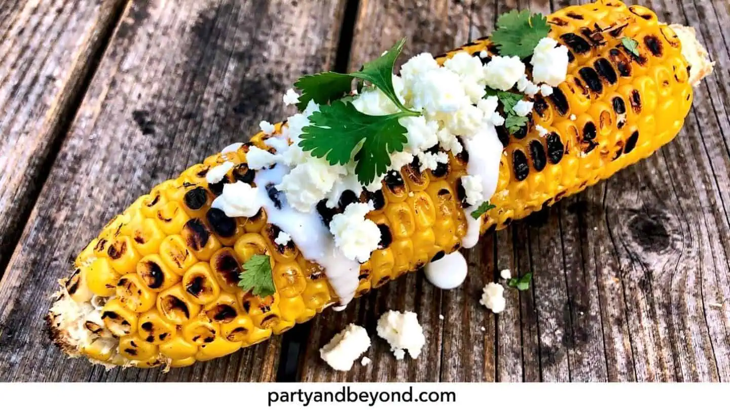 Mexican street corn with cotija cheese and lime on the grill