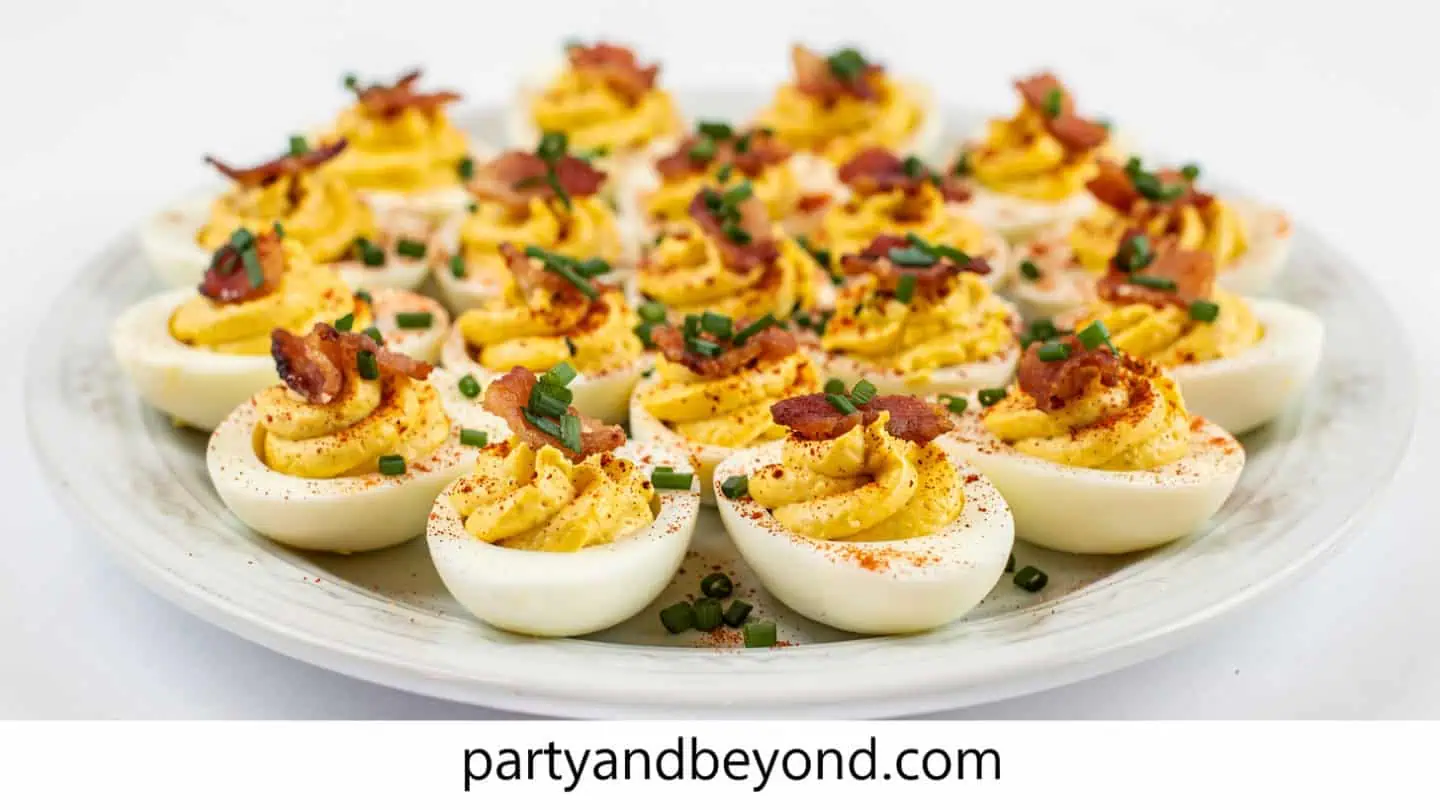 Loaded deviled eggs topped with bacon chives and paprika