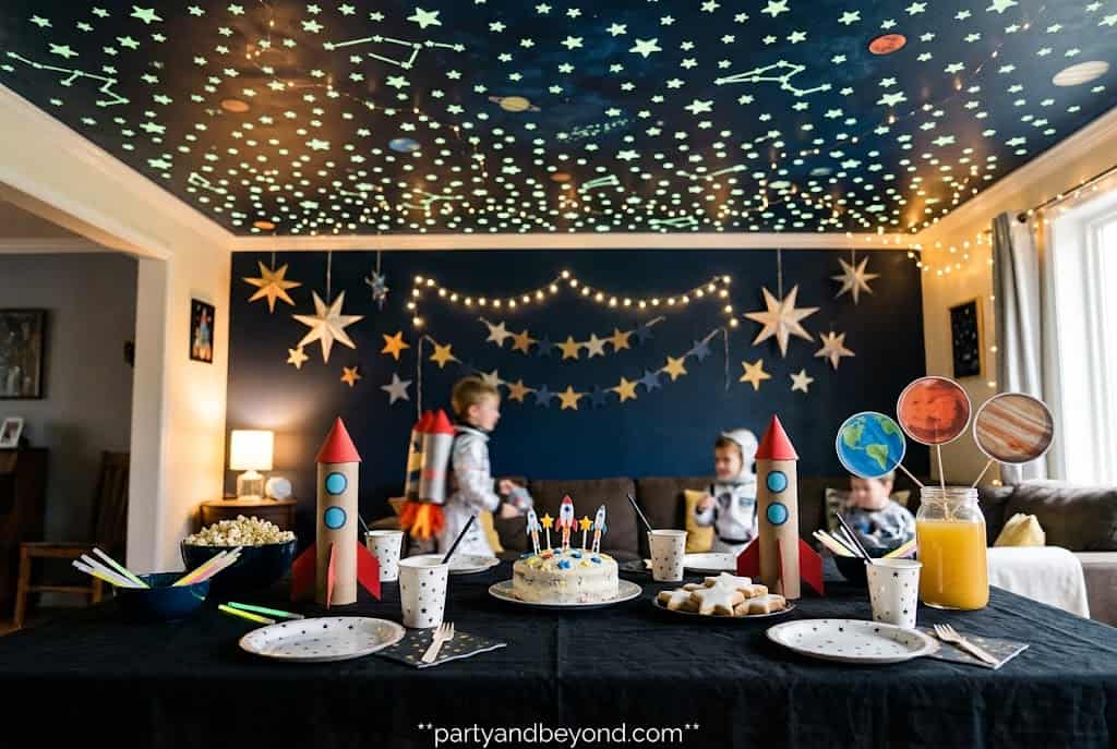 Black party table with glowing ceiling stars creating a magical galaxy atmosphere