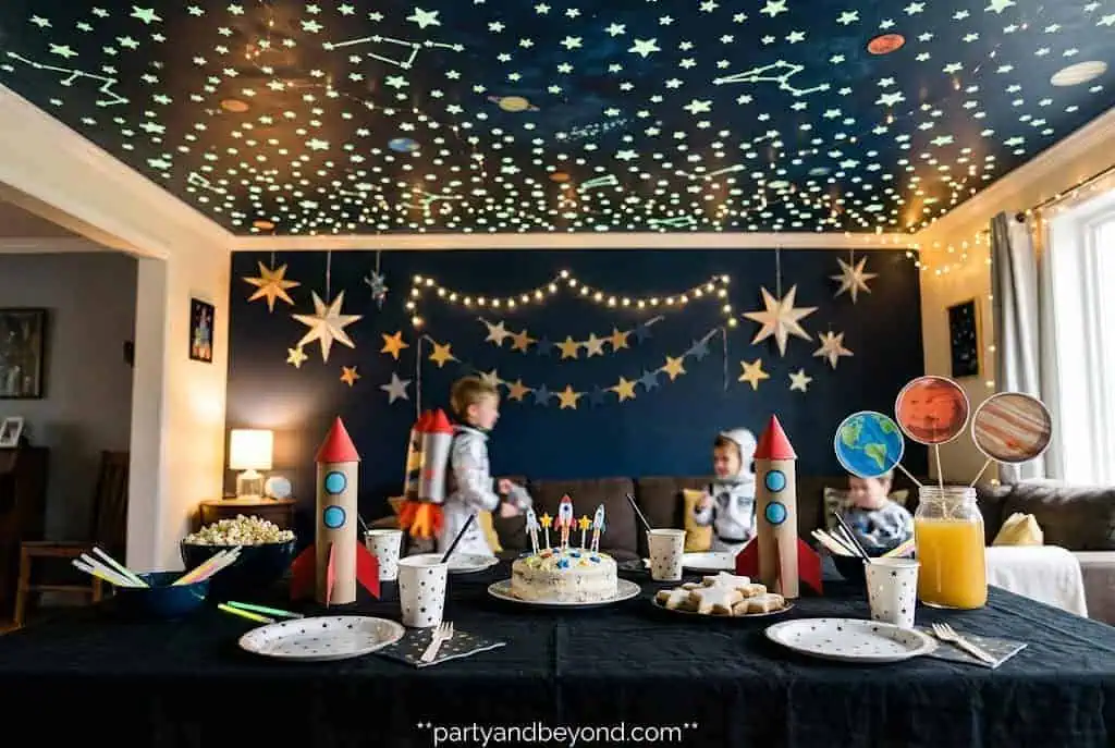 Black party table with glowing ceiling stars creating a magical galaxy atmosphere