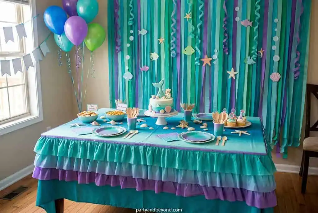 Green and teal streamers hanging like underwater seaweed to create a magical mermaid backdrop.