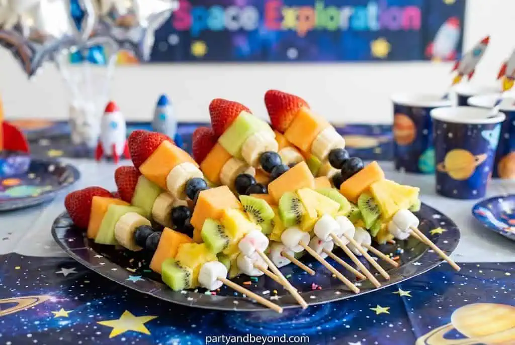 Fresh fruit skewers designed to look like colorful rockets for a healthy party snack.