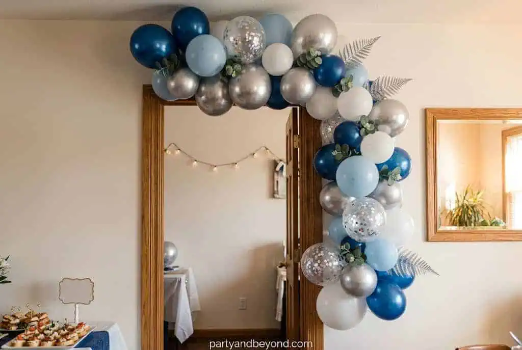 Colorful doorway balloon garland decorating a small apartment party entrance.