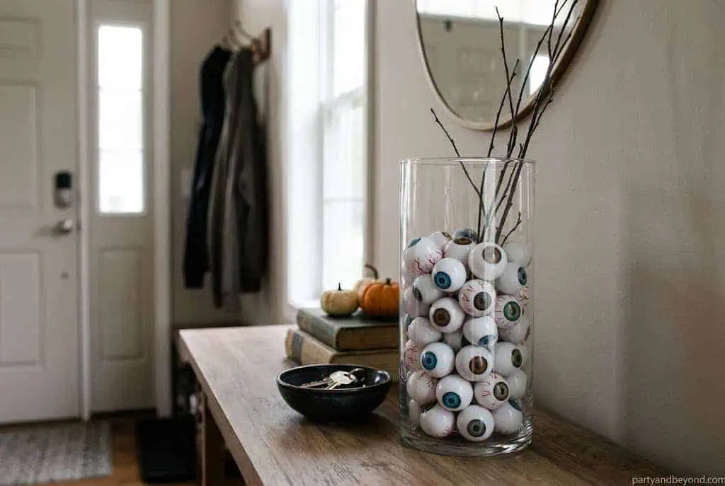 Clear vase filled with black beans and Halloween eyeballs.
