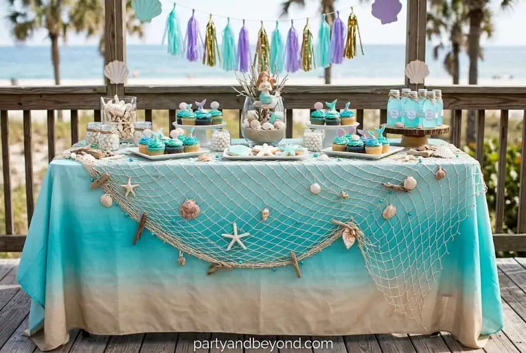 Decorative fishnet draped over a party table with seashells creating an under-the-sea look.