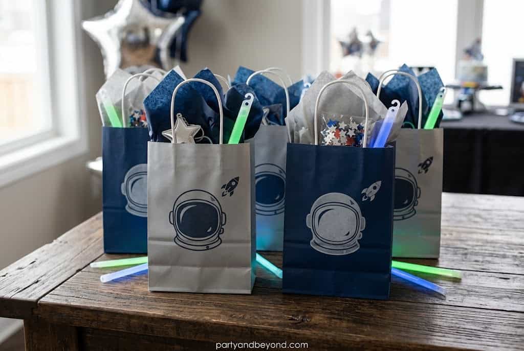 Personalized astronaut-themed party favor bags with fun space gifts for kids.