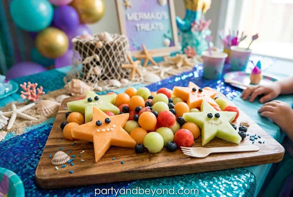 Fresh fruit cut into starfish shapes with colorful melon pieces for a healthy party snack.